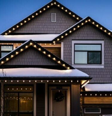 Home outlined in Christmas lights with a decorated lawn