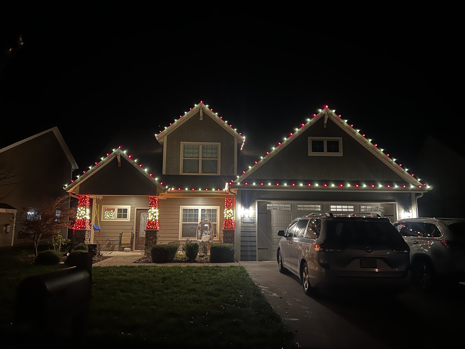 Christmas lights outlining a two-story home and its entryway