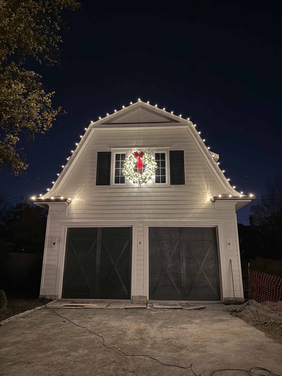 Christmas lights on the gable and roofline above a garage