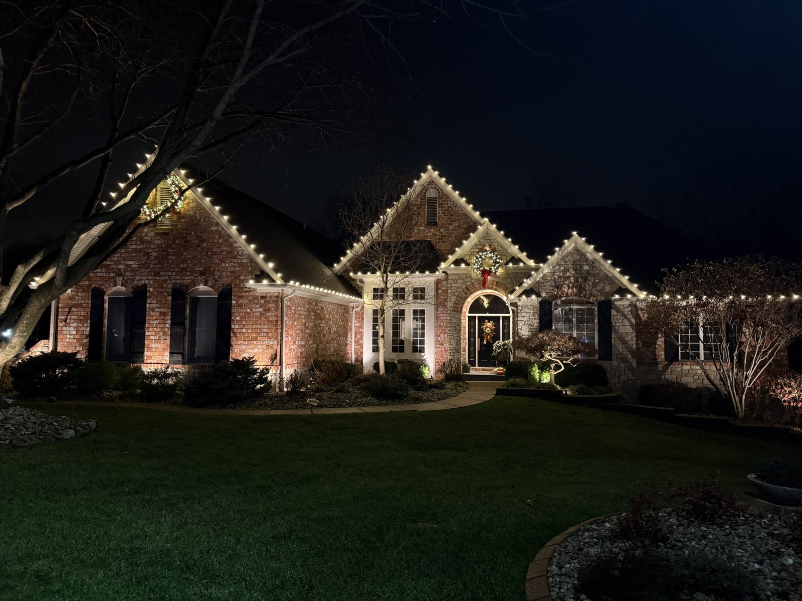 Warm white lights tracing the peaks of a Missouri home
