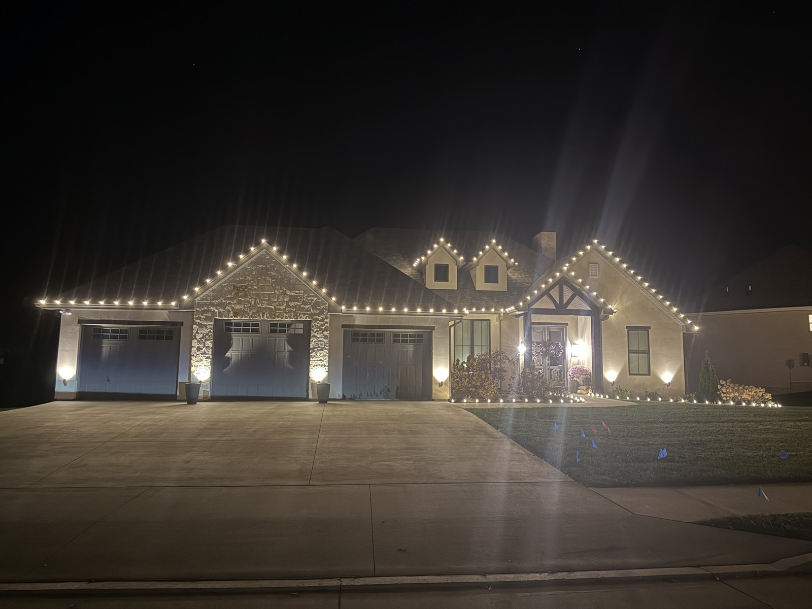 Christmas lights outlining a home and three garage bays