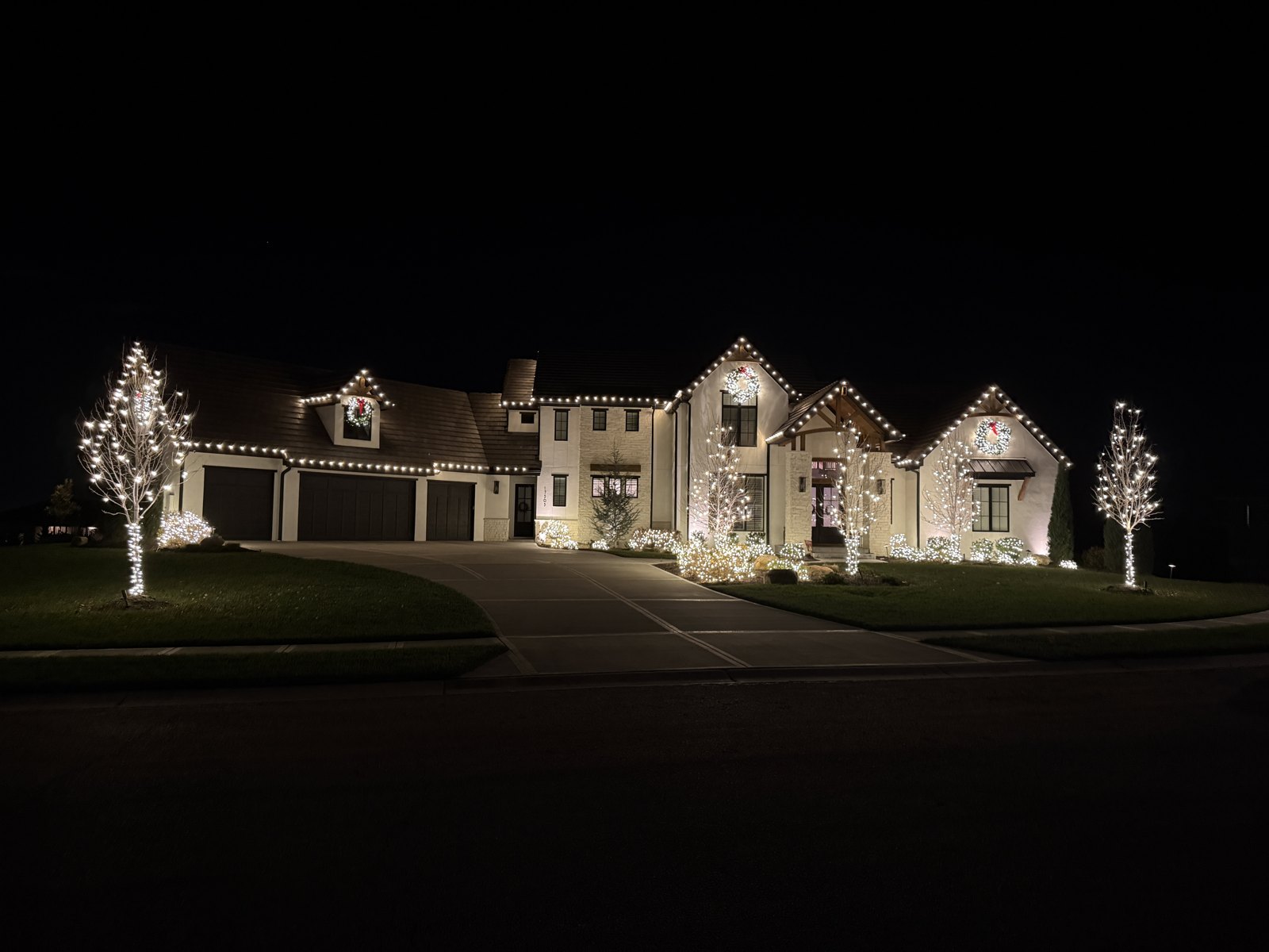 Holiday roofline lights across a two-story home