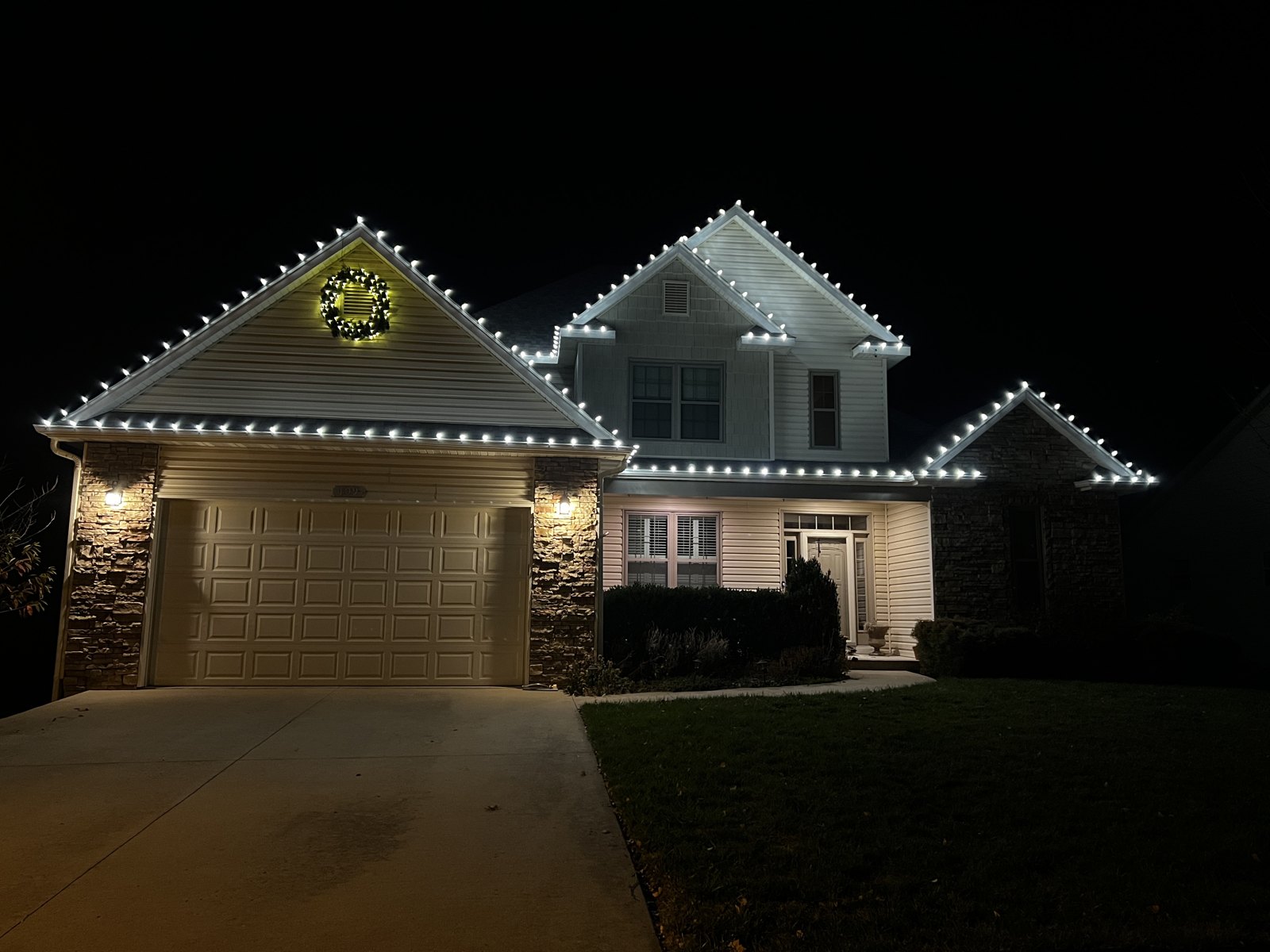 White Christmas lights outlining a home and garage