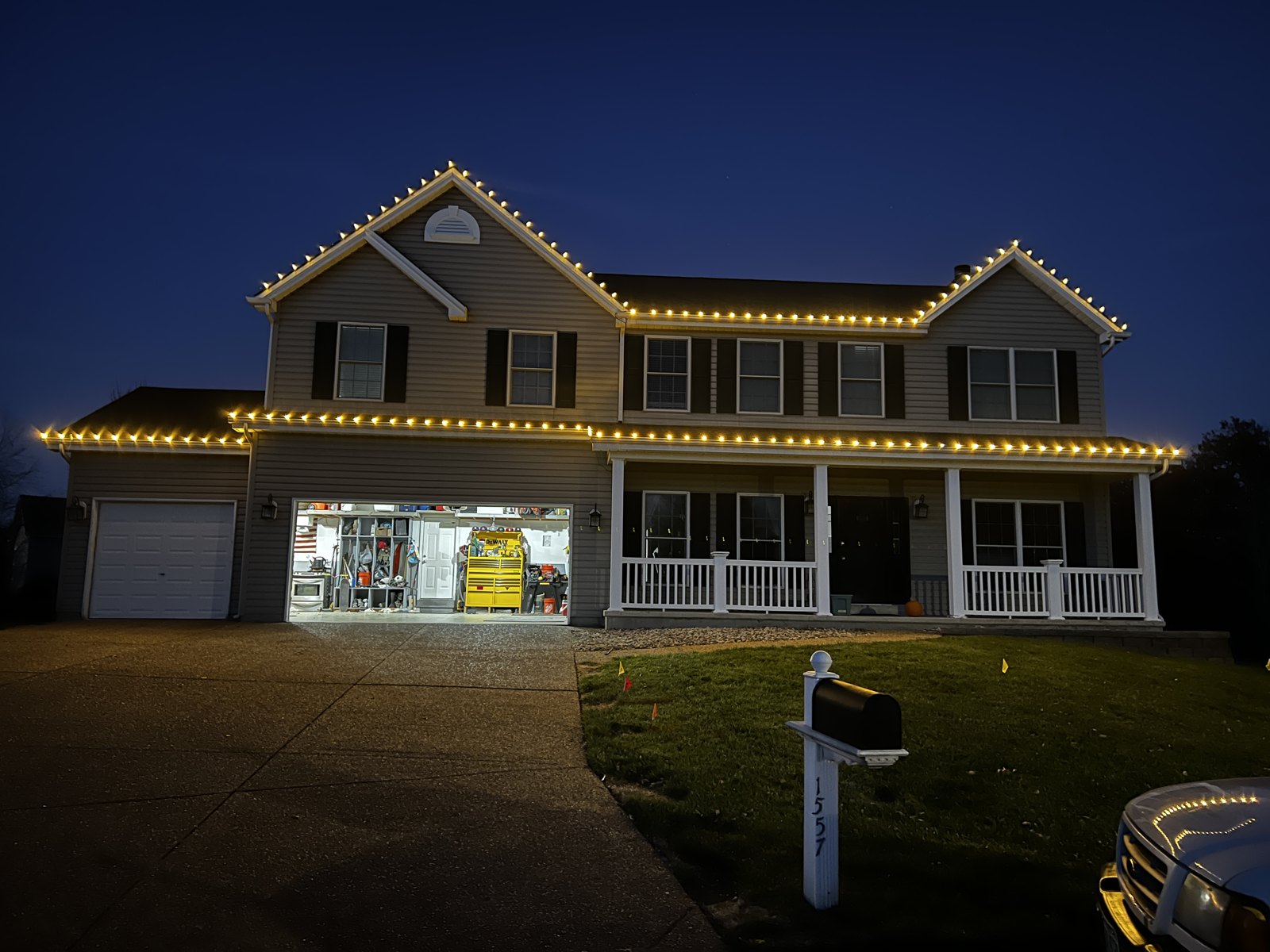 A two-story home with warm white roofline lighting at dusk